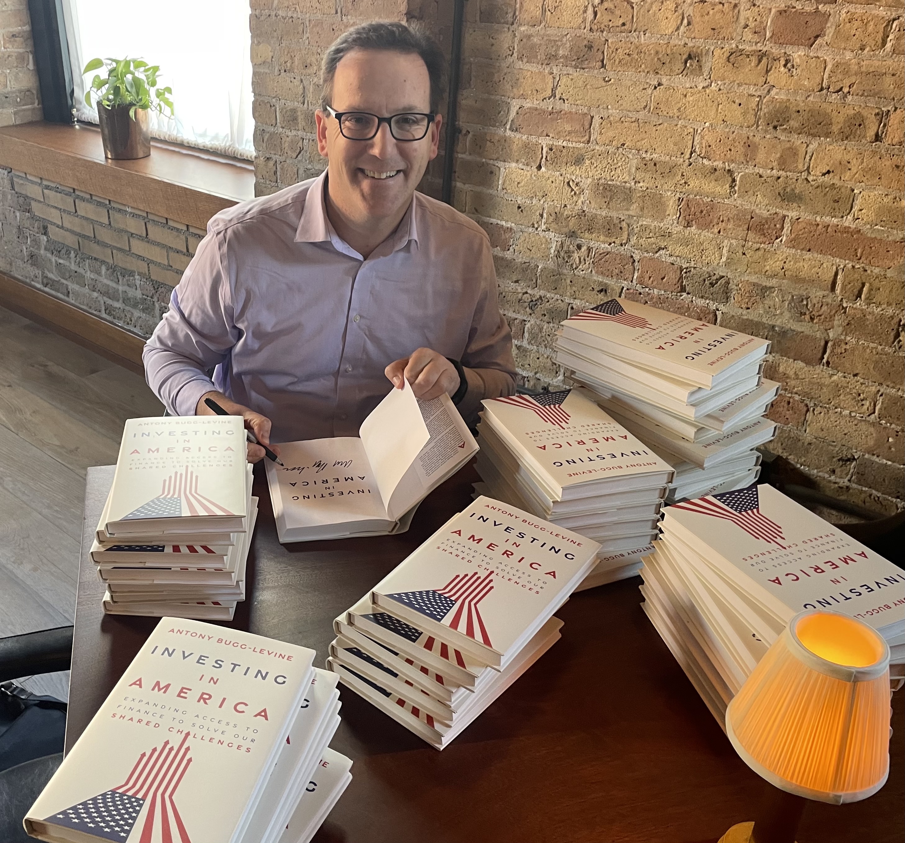 Antony Bugg-Levine signing copies of Investing in America in Chicago